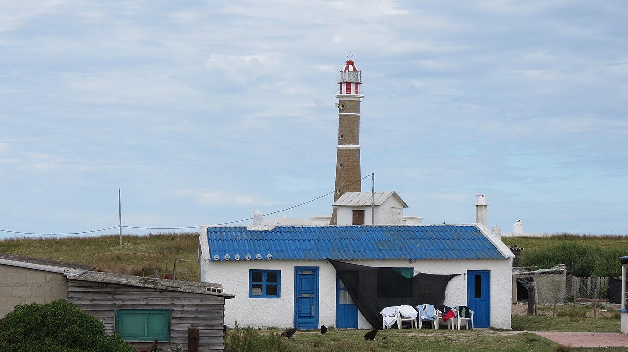 Simple blue-roofed house below the Cabo Polonio lighthouse, with no roads or power lines in sight