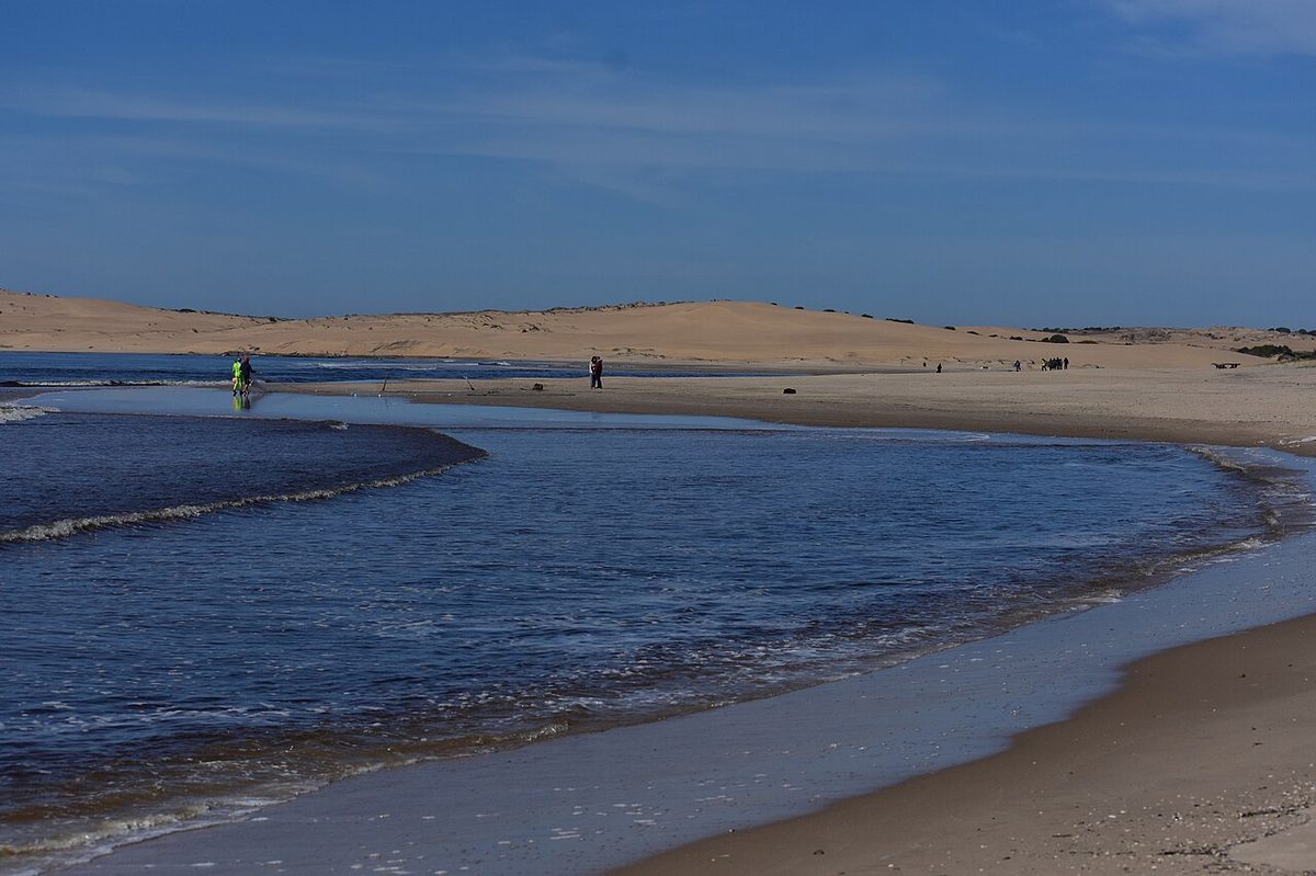 Walkers crossing the wide field of dunes on the trek from Valizas to Cabo Polonio