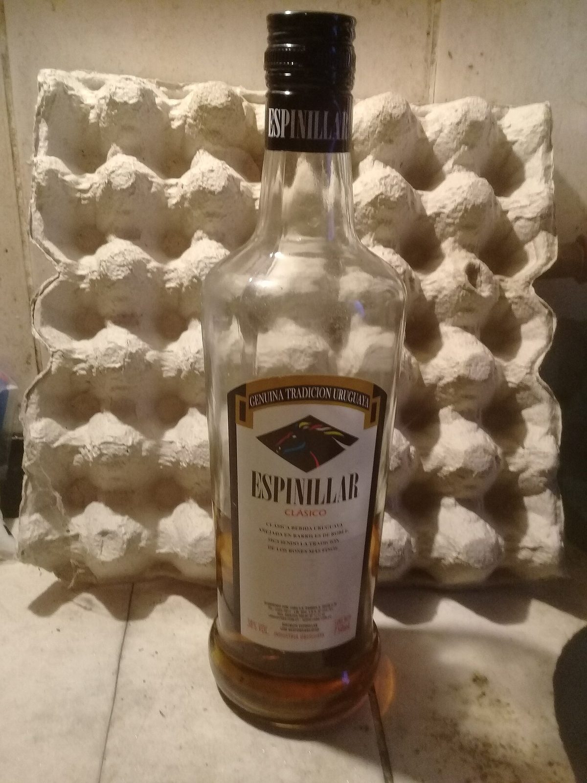 A bottle of Espinillar, the Uruguayan ANCAP label behind grappamiel and caña