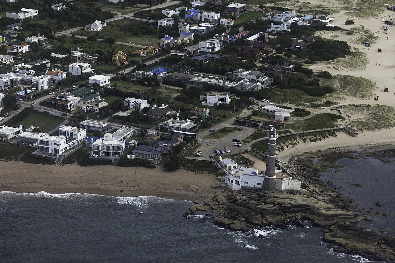 Jos&eacute; Ignacio's lighthouse and low whitewashed houses between two beaches, seen from the air