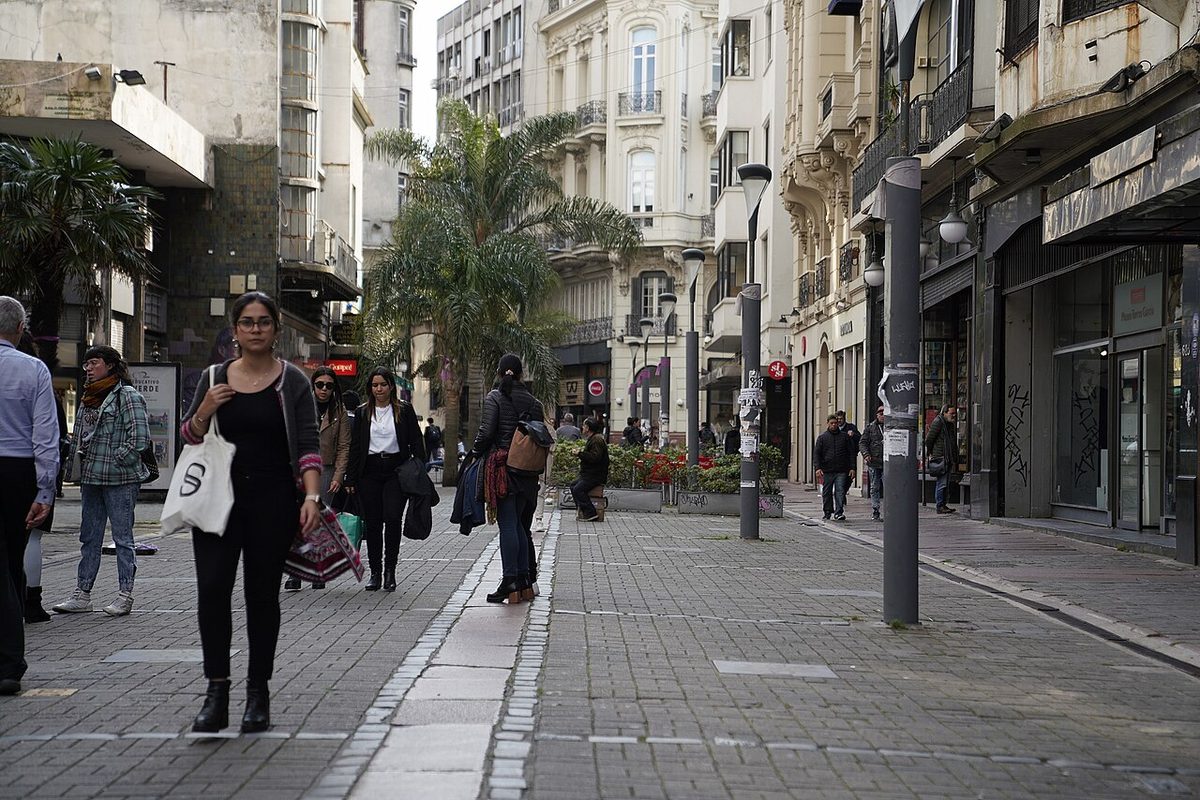 People walking the Peatonal Sarandí in Montevideo, dressed in dark smart-casual layers