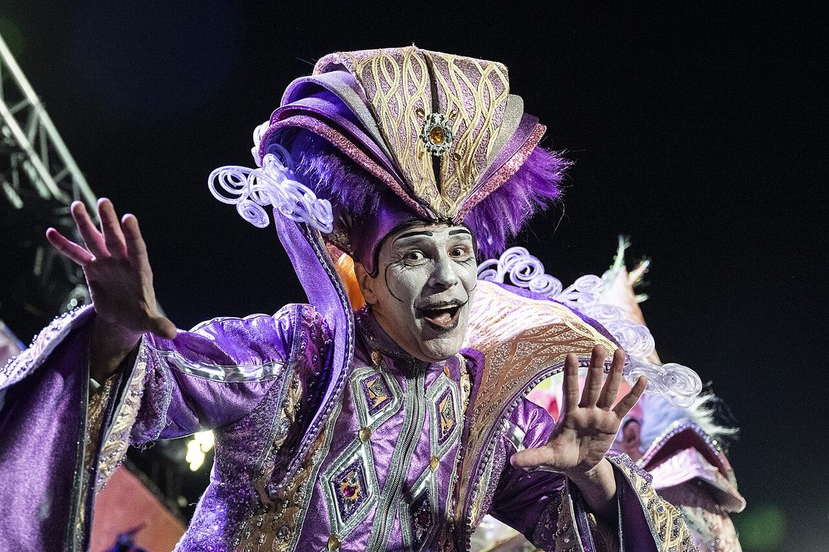 A murga uruguay chorus in painted faces and jester costumes singing on a neighbourhood tablado in Montevideo