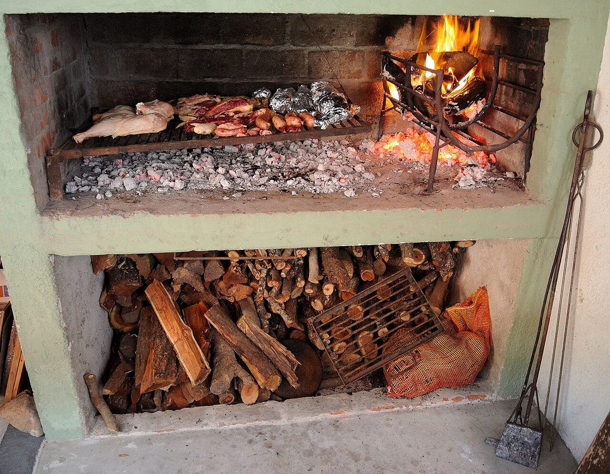 A traditional Uruguayan brick parrilla loaded with beef and firewood
