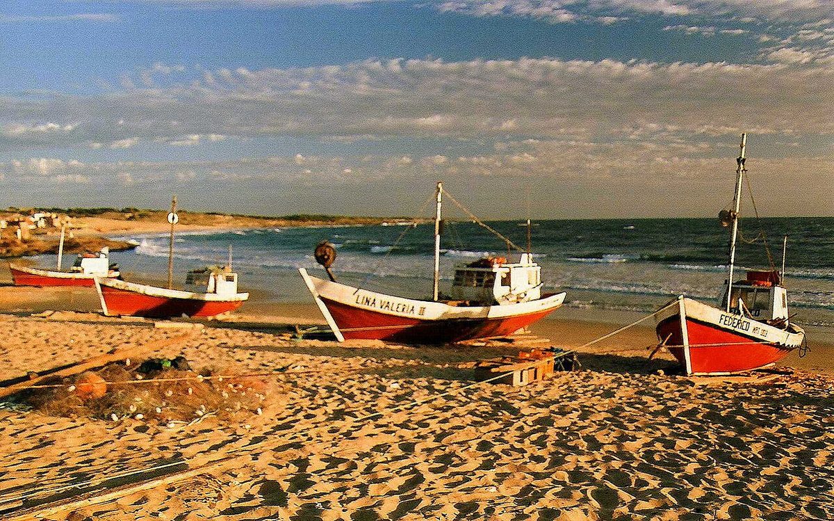 Colourful wooden fishing boats hauled up on the beach at Punta del Diablo, Uruguay