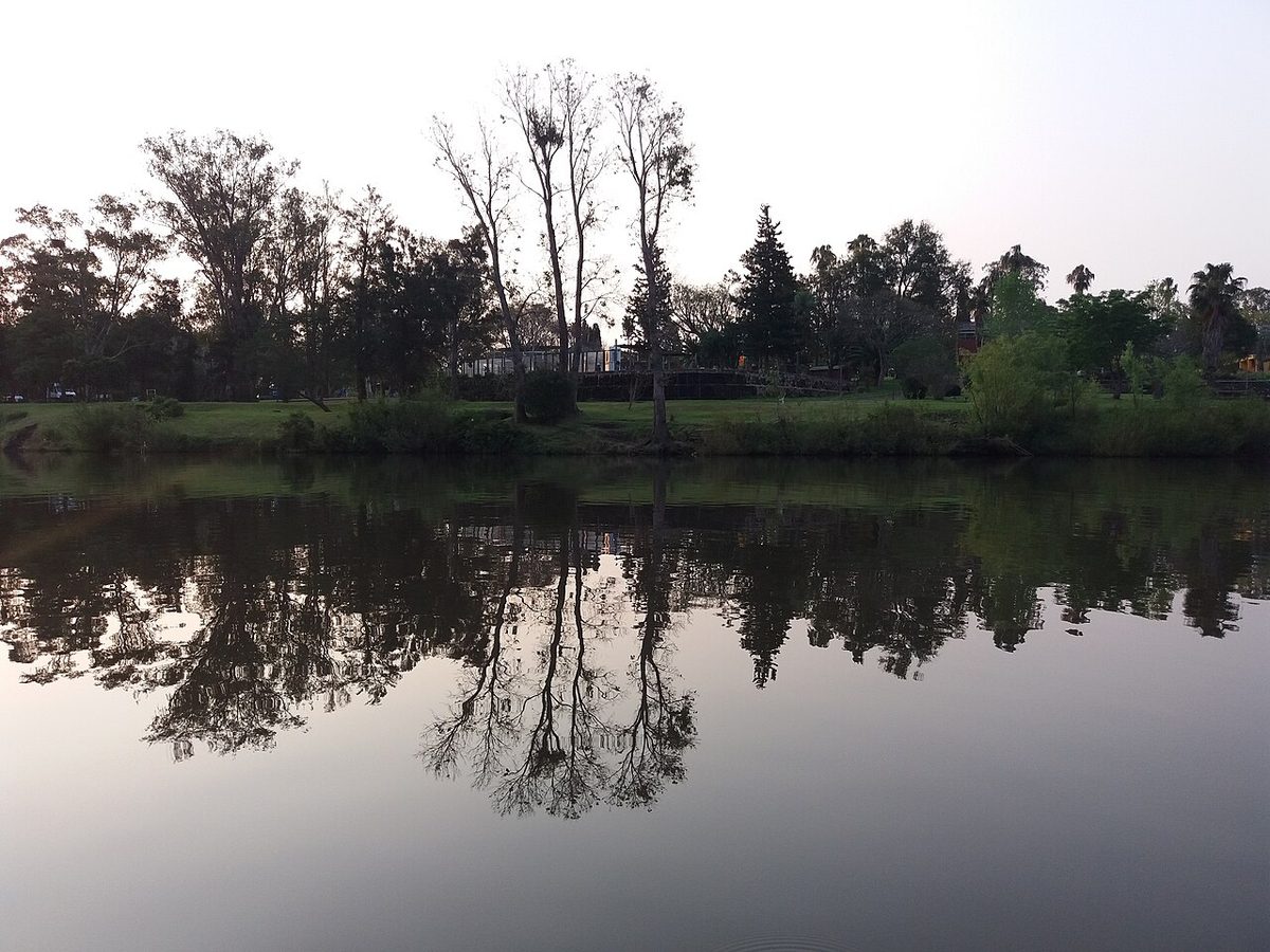 The calm, tree-lined Arapey Grande river beside the thermal resort village