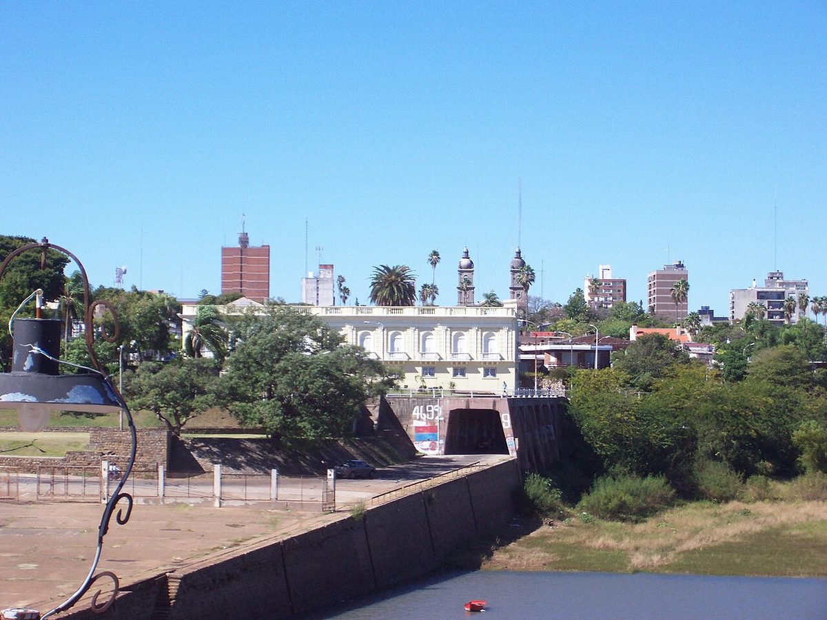 The Rio Uruguay waterfront at Salto Uruguay at golden hour, with the wide river and the Argentine bank beyond