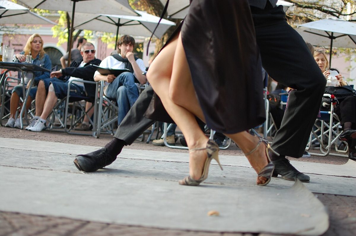 Close-up of dancers' feet performing tango steps on a wooden floor