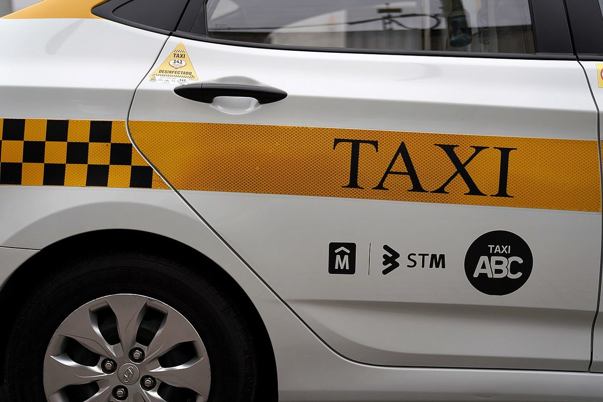 A white-and-yellow Montevideo street taxi waiting at a downtown corner