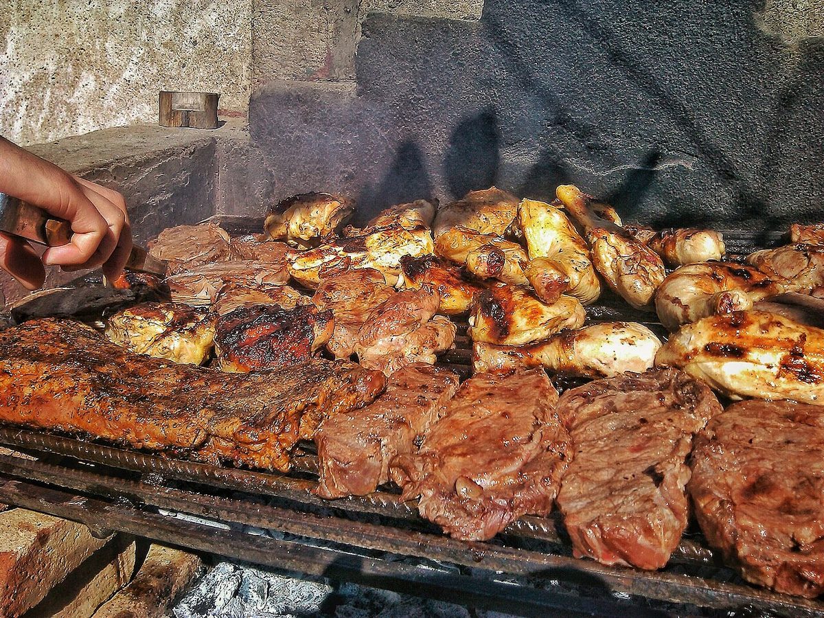 Open-fire grilling over wood coals, the live-fire cooking style at the heart of Uruguay's winery restaurants