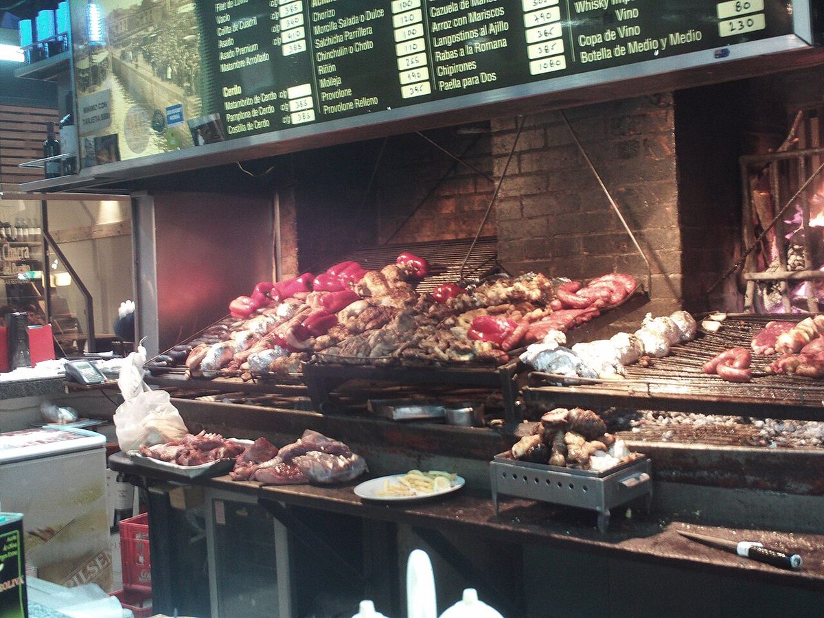 Uruguayan asado cooking slowly over a wood-fired parrilla