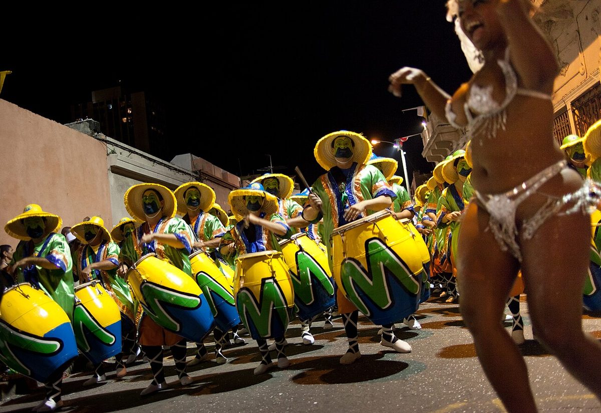 A vedette in a feathered costume dancing in front of the drummers at Las Llamadas in Montevideo